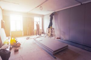 Workers installing drywall boards on interior walls during drywall boarding project in Abbotsford