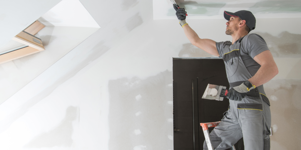 Professional drywall installer applying joint compound to ceiling during drywall finishing in Chilliwack.